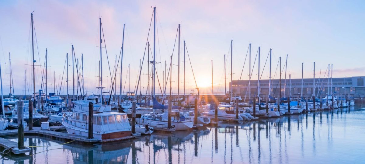 Row of boats moored at a marina in the San Francisco bay at sunset